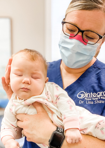 Dr. Lisa Shaw providing physical therapy services to an infant